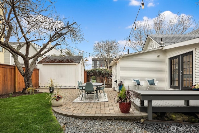 exterior space featuring an outbuilding, french doors, a storage shed, and a fenced backyard