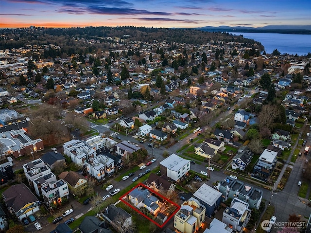 aerial view at dusk featuring a water view