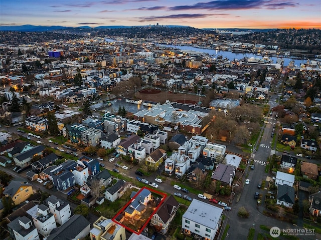 aerial view at dusk featuring a water view