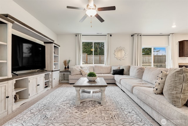 carpeted living area featuring ceiling fan