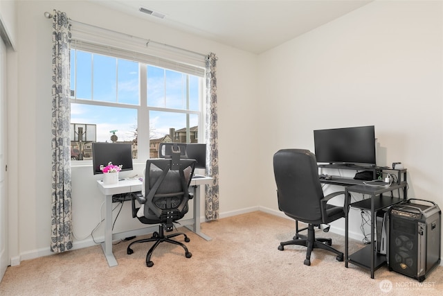 carpeted office with a wealth of natural light, visible vents, and baseboards