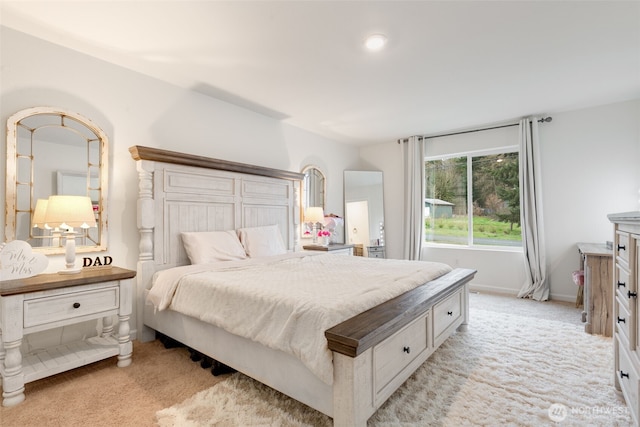 bedroom with light colored carpet and baseboards