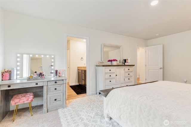 bedroom with ensuite bathroom and baseboards