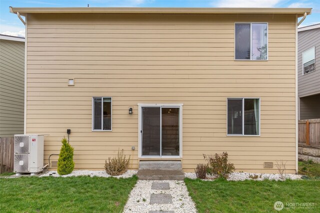 rear view of property with central air condition unit, a yard, fence, and crawl space