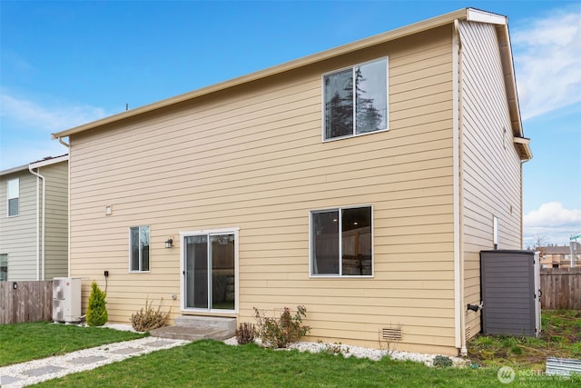 rear view of property featuring a yard and fence