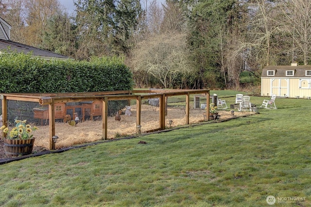 view of yard featuring a storage shed, an outdoor structure, and a vegetable garden