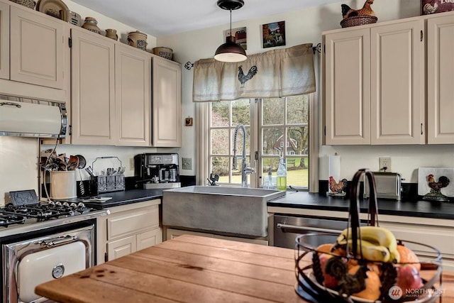 kitchen with decorative light fixtures, white cabinetry, and a sink