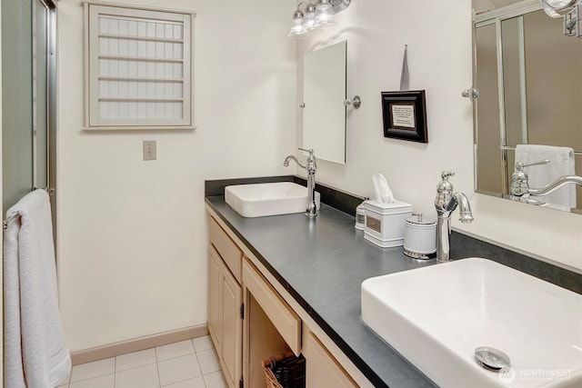 bathroom featuring a shower stall, double vanity, tile patterned floors, and a sink