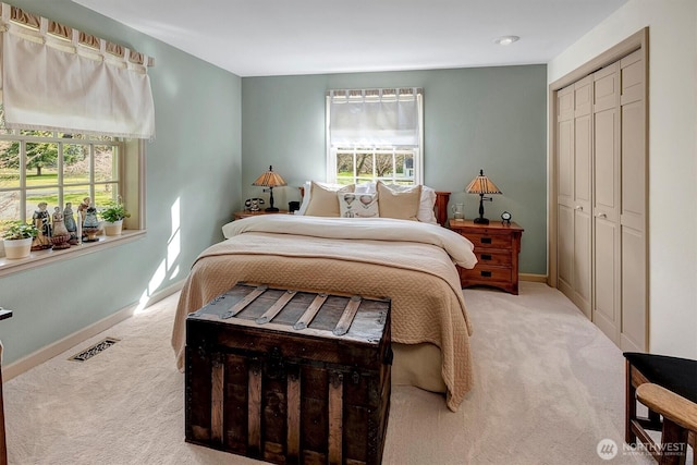 carpeted bedroom with visible vents, multiple windows, baseboards, and a closet