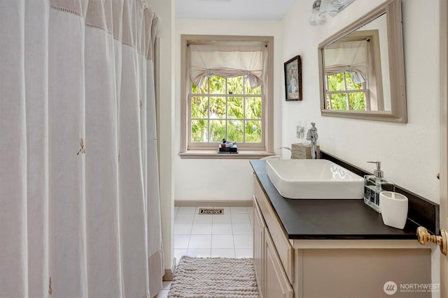 bathroom with a wealth of natural light, tile patterned flooring, vanity, and baseboards