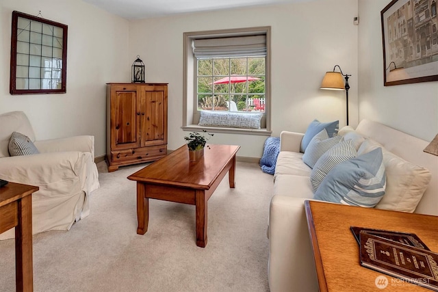 living area with light colored carpet and baseboards