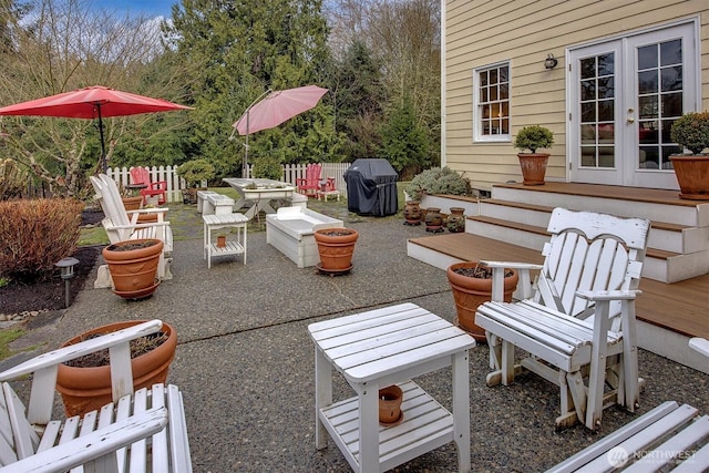 view of patio featuring french doors, area for grilling, outdoor dining space, and fence