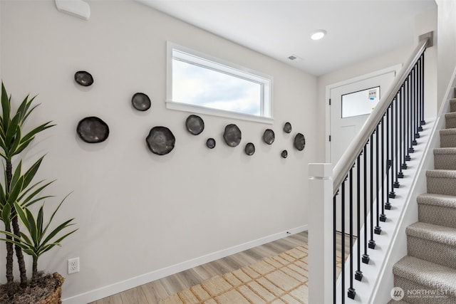 stairs featuring visible vents, wood finished floors, and baseboards