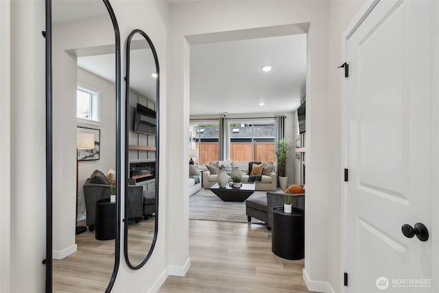 corridor with recessed lighting, baseboards, and light wood-style floors