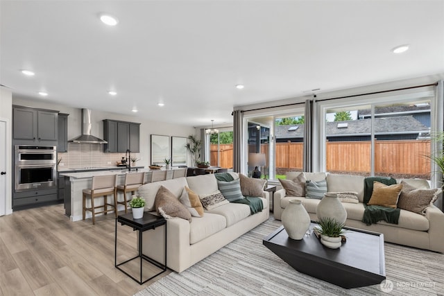 living room featuring recessed lighting, light wood-style floors, and a chandelier