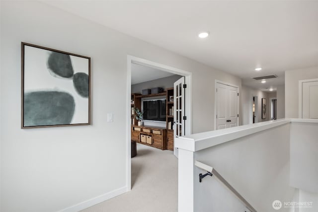 hallway featuring an upstairs landing, visible vents, light colored carpet, and recessed lighting