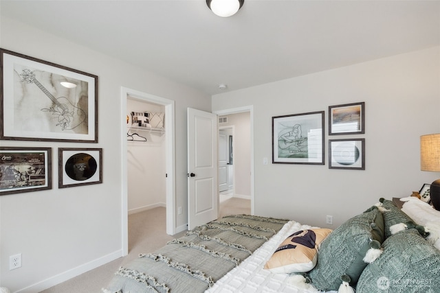 carpeted bedroom with a spacious closet, baseboards, visible vents, and a closet