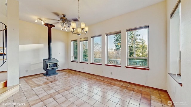 unfurnished dining area featuring light tile patterned floors, a notable chandelier, and a wood stove