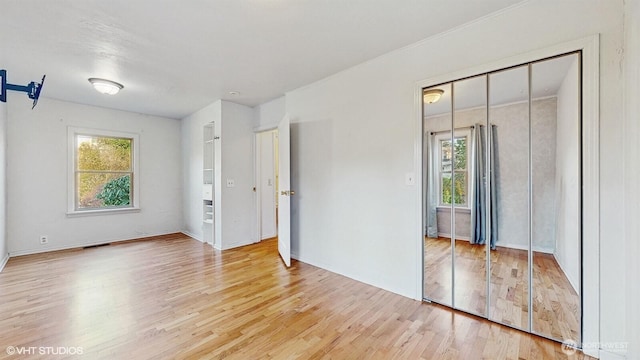 unfurnished bedroom featuring a closet, visible vents, and wood finished floors