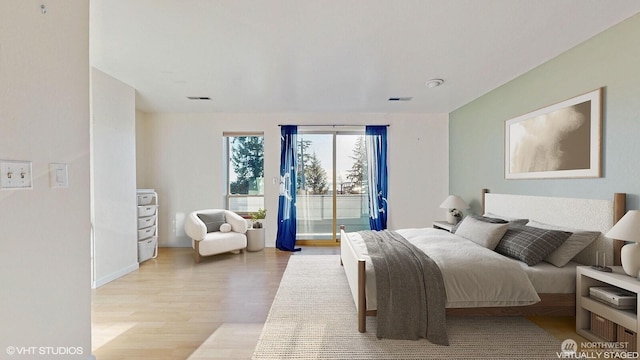 bedroom featuring access to outside, light wood-style floors, and visible vents