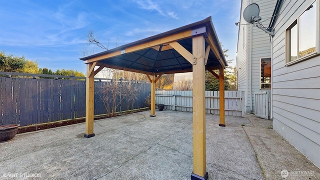 view of patio / terrace featuring a gazebo, a carport, and a fenced backyard