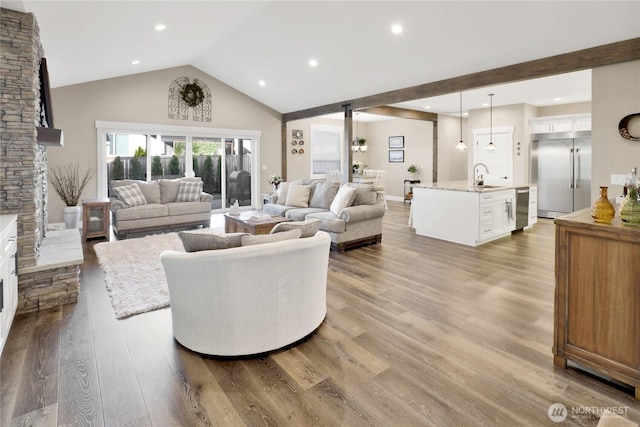 living area featuring recessed lighting, high vaulted ceiling, and wood finished floors