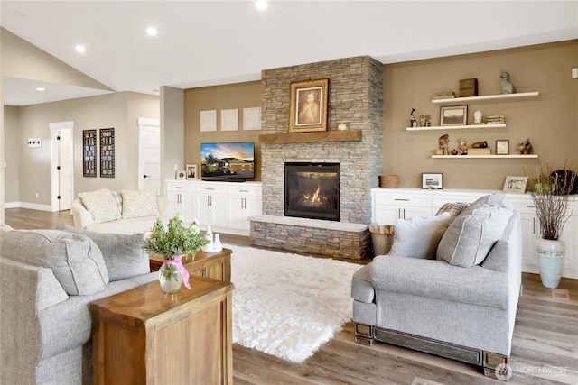 living room featuring vaulted ceiling, recessed lighting, a fireplace, and wood finished floors