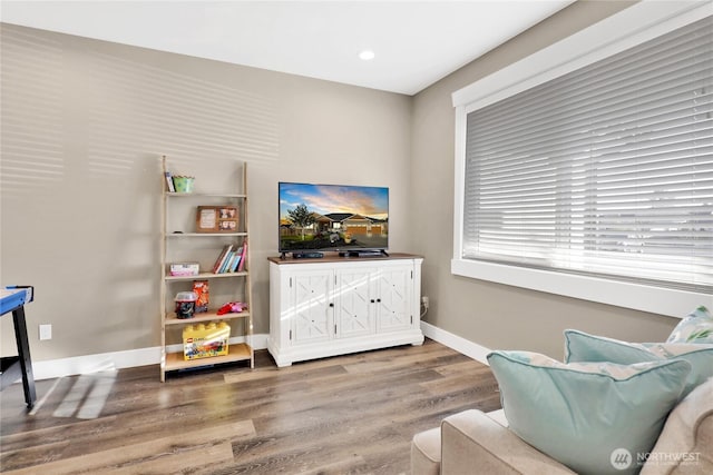 living area featuring recessed lighting, baseboards, and wood finished floors