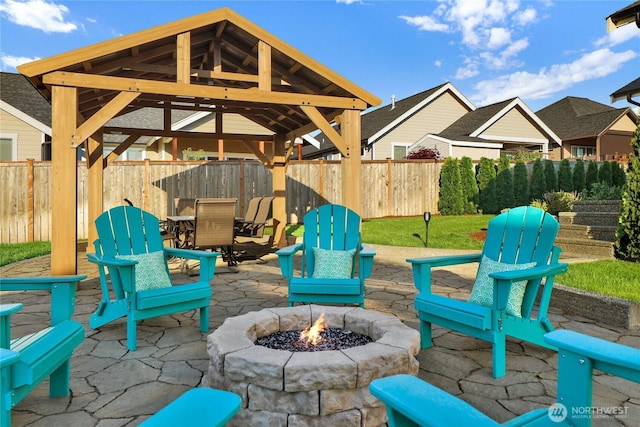 view of patio / terrace featuring a gazebo, outdoor dining area, a fire pit, and fence