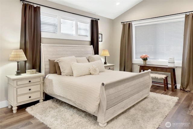 bedroom with recessed lighting, wood finished floors, baseboards, and vaulted ceiling