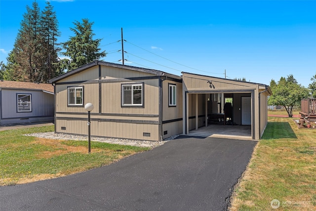 manufactured / mobile home featuring crawl space, an attached carport, driveway, and a front yard