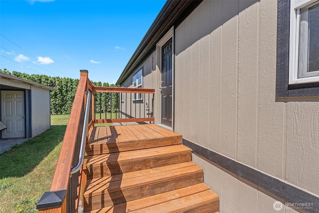 wooden terrace featuring a yard and an outdoor structure