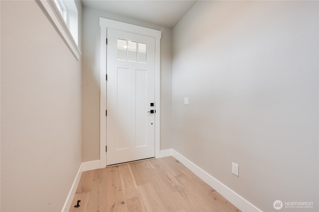 doorway featuring baseboards and light wood-style floors