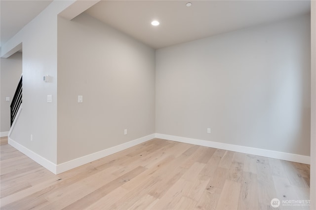 empty room featuring recessed lighting, light wood-type flooring, and baseboards