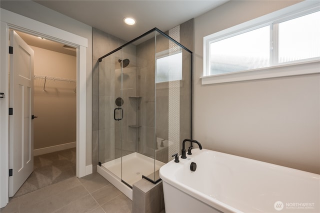 full bath with a soaking tub, recessed lighting, a shower stall, a walk in closet, and tile patterned floors