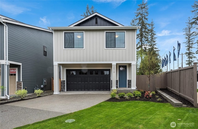 view of front of property featuring fence, driveway, an attached garage, a front lawn, and board and batten siding