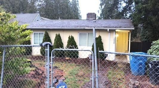 view of front facade with a chimney and fence