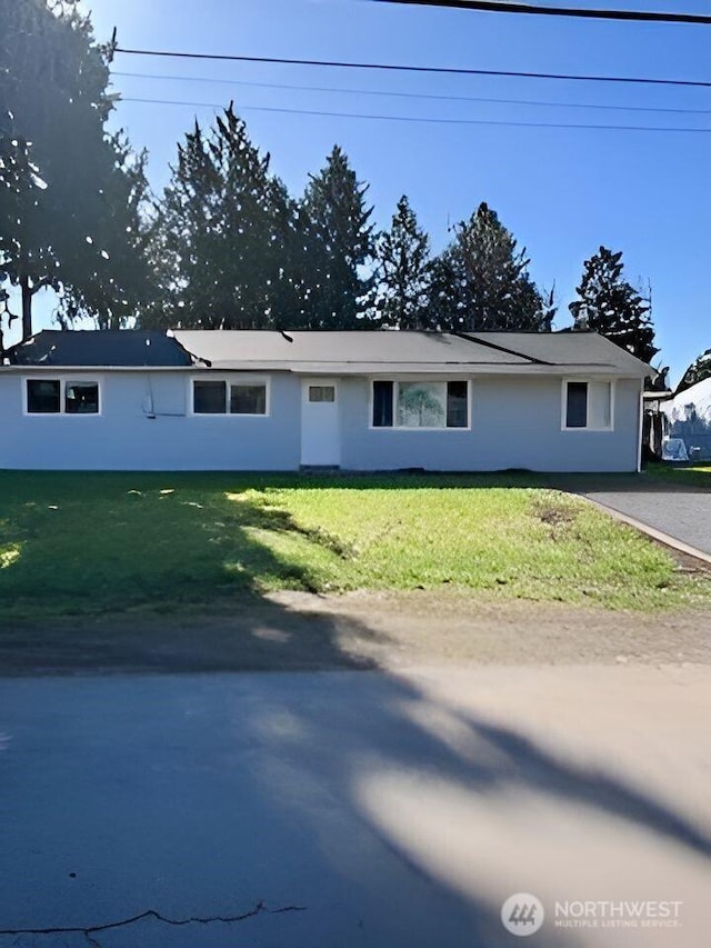 ranch-style home with driveway and a front yard