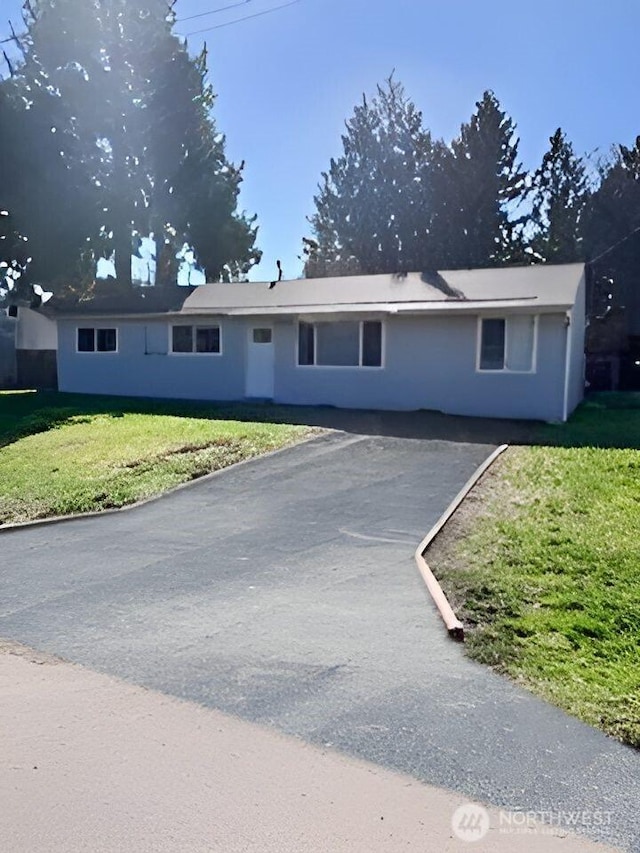 single story home featuring aphalt driveway and a front yard