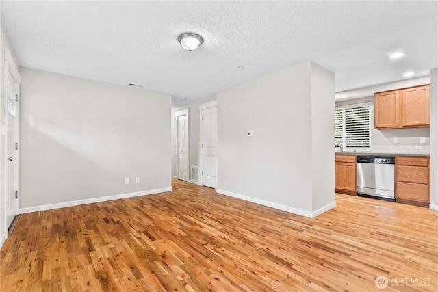 interior space featuring light wood-type flooring, visible vents, a textured ceiling, recessed lighting, and baseboards