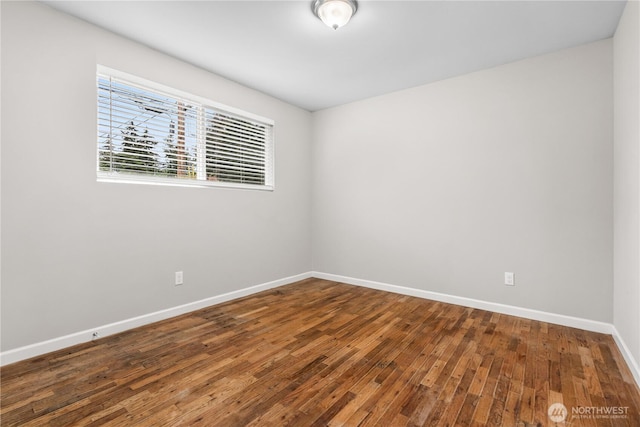 unfurnished room featuring baseboards and hardwood / wood-style flooring