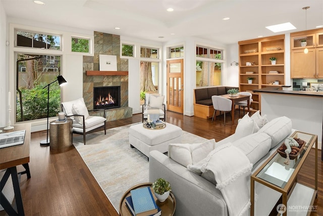 living area with recessed lighting, wood finished floors, and a fireplace