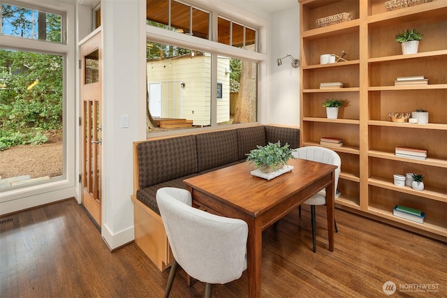 dining area with a wealth of natural light, dark wood-style floors, and baseboards