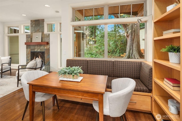 dining area featuring recessed lighting, a large fireplace, and wood finished floors