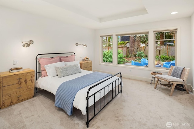 bedroom featuring a tray ceiling, recessed lighting, baseboards, and light carpet