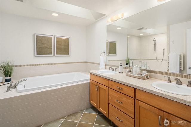 full bathroom featuring a sink, double vanity, a bath, and tile patterned floors