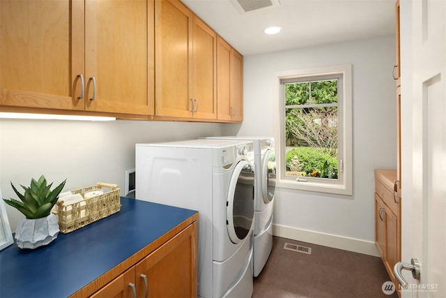 laundry area featuring separate washer and dryer, cabinet space, visible vents, and baseboards