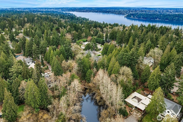 bird's eye view featuring a wooded view and a water view