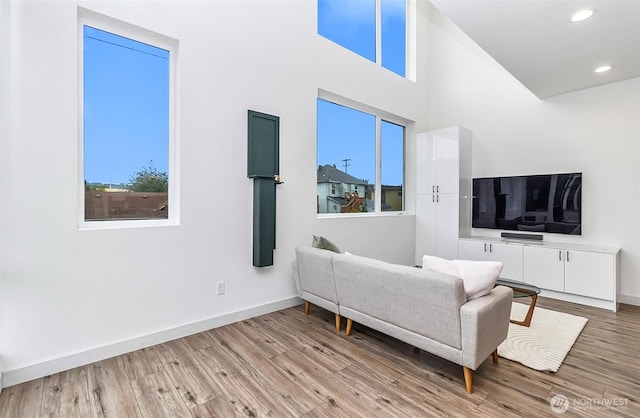 living room featuring recessed lighting, baseboards, and wood finished floors