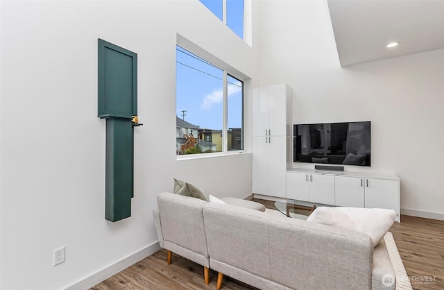 living area featuring recessed lighting, baseboards, and wood finished floors